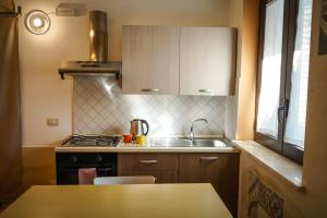 a small kitchen with a sink and a stove at La Muzza Bed & Breakfast in Zollino