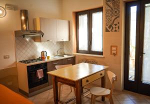 a small kitchen with a wooden table and a stove at La Muzza Bed & Breakfast in Zollino