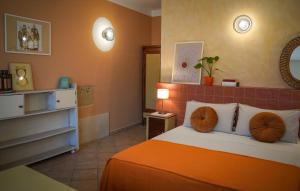 a bedroom with a bed with an orange blanket at La Muzza Bed & Breakfast in Zollino
