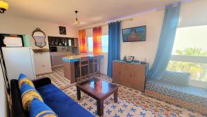 a living room with a blue couch and a table at Maison de la Lagune in Oualidia