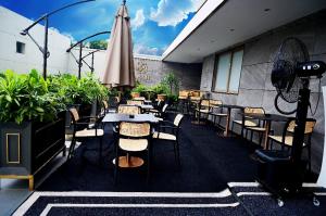 ein Restaurant mit Tischen, Stühlen und einem Sonnenschirm in der Unterkunft Best Hotel in Lagos - The Delborough in Lagos