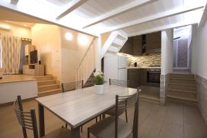 Un comedor y una cocina con mesa y sillas. en Gaia Holiday House, en Grottaferrata