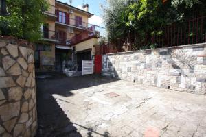 una pared de piedra junto a un edificio en Gaia Holiday House, en Grottaferrata