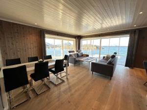 a living room with a table and chairs and the ocean at Lofoten Panorama in Stamsund