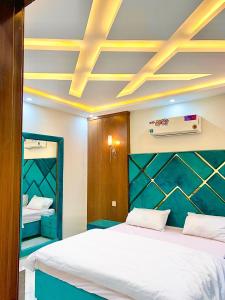 ラホールにあるRoyal Height Residenceのベッド2台と天井のある寝室