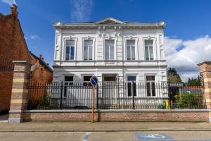 a white house with a fence in front of it at Luxeverblijf B&B het Wevershuis in Herentals