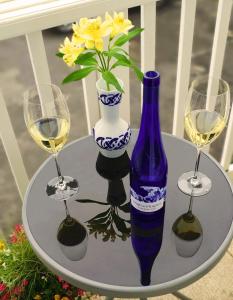 ボーンマスにあるA Beautiful Apartment with Stunning Sea Views & Private Balconyのワイングラス3杯と青い花瓶が置かれたテーブル