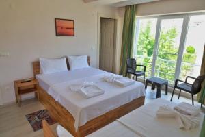a bedroom with a large bed and a large window at Eceabat Doğa Pansiyon-Hotel in Eceabat
