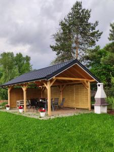 a large wooden cabin with a black roof at Pokoje Gościnne Pod Lipami in Kudowa-Zdrój
