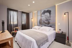 a bedroom with a large bed with a painting on the wall at CW Athens Riviera Suite in Athens