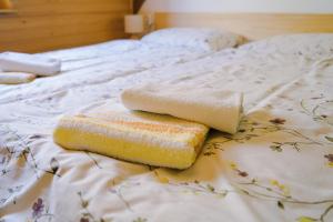 a bed with two towels on top of it at V objemu gora in Bohinj