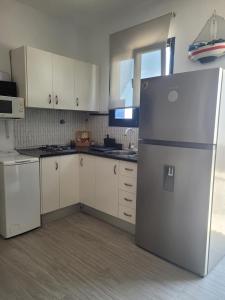 a kitchen with white cabinets and a refrigerator at Casa Noda Tarajalejo in Tarajalejo