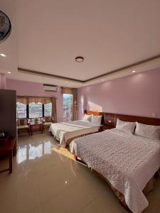- une chambre avec 2 lits et une table dans l'établissement Tam Giác Mạch Hotel, à Ha Giang