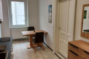 una pequeña cocina con una mesa de madera y una ventana en Appartement Top5b - Budget, en Linz