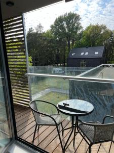 a balcony with a table and chairs on a deck at Apartamentai Palangos Kopos in Palanga