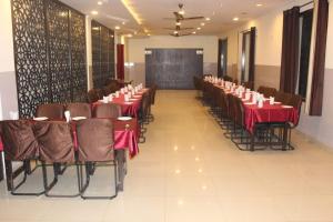 una sala conferenze con tavoli, sedie e lavagna di Hotel Bhavani Palampur a Pālampur