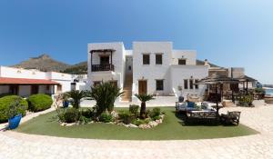 a large white house with a patio and lawn at Panteli Beach Hotel in Panteli