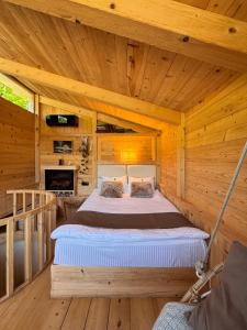 ボルジョミにあるHotel Borjomi Verdeの木造キャビン内のベッド1台が備わるベッドルーム1室を利用します。