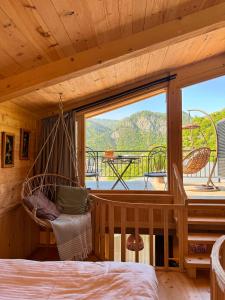 a bedroom with a hammock and a large window at Hotel Borjomi Verde in Borjomi