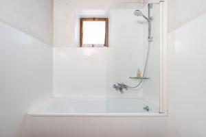 een witte badkamer met een bad en een raam bij Casa dei Camini Venetian Villa in Caprino Veronese