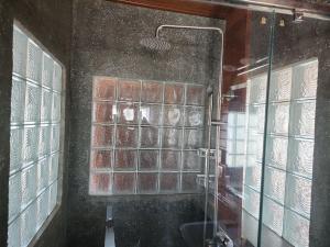 a bathroom with a shower with a glass wall at CHILCHILL Elite Residences BKK2 in Phnom Penh