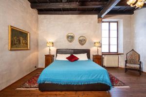 een slaapkamer met een bed met een blauwe deken bij Casa dei Camini Venetian Villa in Caprino Veronese