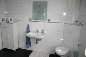a white bathroom with a sink and a toilet at Appartment Herten - Auch zur EM 2024 Arena AufSchalke in Herten