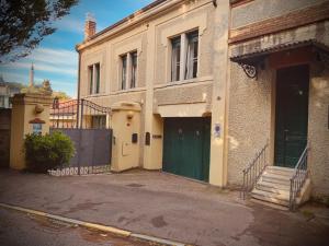 an old house with a green door on a street at Le Residenze dei Serravallo in Trieste