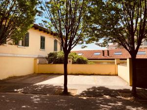 a house with a parking lot and two trees at Le Residenze dei Serravallo in Trieste