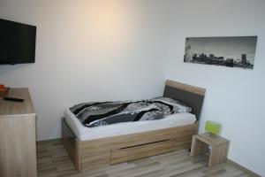 een slaapkamer met een bed en een tv aan de muur bij Appartment Herten - Auch zur EM 2024 Arena AufSchalke in Herten