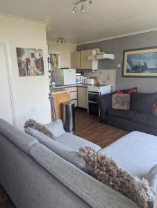 uma sala de estar com 2 camas e uma cozinha em Springside Chalet20 em Tywyn