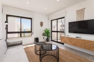 uma sala de estar com uma televisão de ecrã plano e uma mesa em Seashore Rosamar em Armação de Pêra