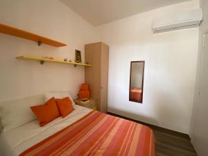 - une chambre avec un lit et des oreillers orange dans l'établissement Villino Oleandro, à Santa Maria Del Focallo