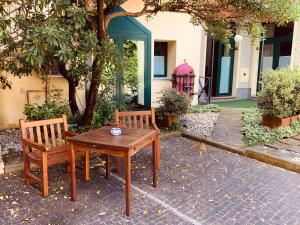 two chairs and a wooden table in front of a house at Le Residenze dei Serravallo in Trieste