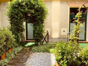 a garden with a building with a door and ivy at Le Residenze dei Serravallo in Trieste