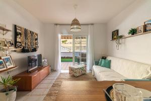 een woonkamer met een bank en een tv bij Los Cristianos El Mirador - As de Casas in Los Cristianos