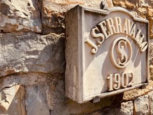 得利雅斯特的住宿－Le Residenze dei Serravallo，石墙边的标志