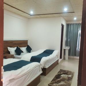 1 dormitorio con 2 camas y ventana en Hotel Geeta Badrinath, en Badrīnāth