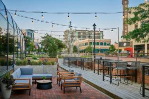 a patio with tables and chairs on a city street at Delta Hotels by Marriott Muskegon Convention Center in Muskegon