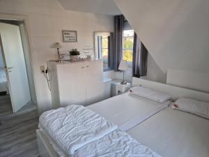 a white room with a bed and a window at Köster, Birgit FW 5 in Zingst