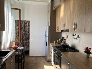 a kitchen with wooden cabinets and a stove top oven at Green House Marina in Batumi