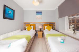2 camas individuais num quarto com uma janela em Cozy City Centre 2 Bedroom Apt by the Meadows! 5 em Edimburgo
