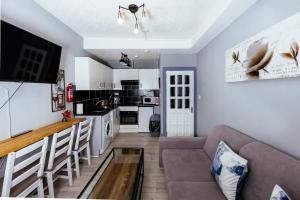 uma sala de estar com um sofá e uma mesa em Cozy City Centre 2 Bedroom Apt by the Meadows! 5 em Edimburgo