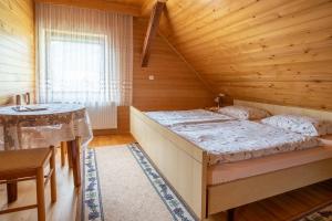 1 dormitorio con 1 cama en una habitación de madera en Apartmaji Skantar, en Bohinj