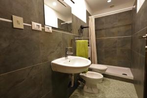 a bathroom with a sink and a toilet and a mirror at travel to meet new friends new loves - age limit 18-40 - checkin Via Roma 59A in Palermo