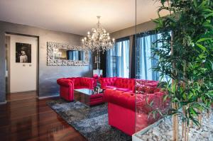 una sala de estar con sofás rojos y una lámpara de araña. en Boutique Hotel Chevalier - Adults Only en Medulin