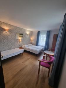 een hotelkamer met 2 bedden en een stoel bij Pokoje gościnne "Mila" in Kąty Rybackie