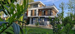 a house with a balcony on top of it at Black Sea Villa (Shekvetili-Kaprovani) in Shekvetili