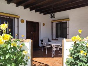 een patio met gele bloemen en een tafel en stoelen bij Casa Villazo II in Almáchar