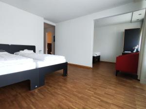 1 dormitorio con 2 camas y TV de pantalla plana en B&B Hotel Mattli Übernachtung Frühstück, en Morschach